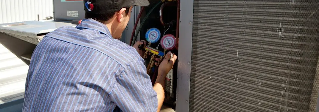 HVAC technician servicing a condenser unit in Red Lion